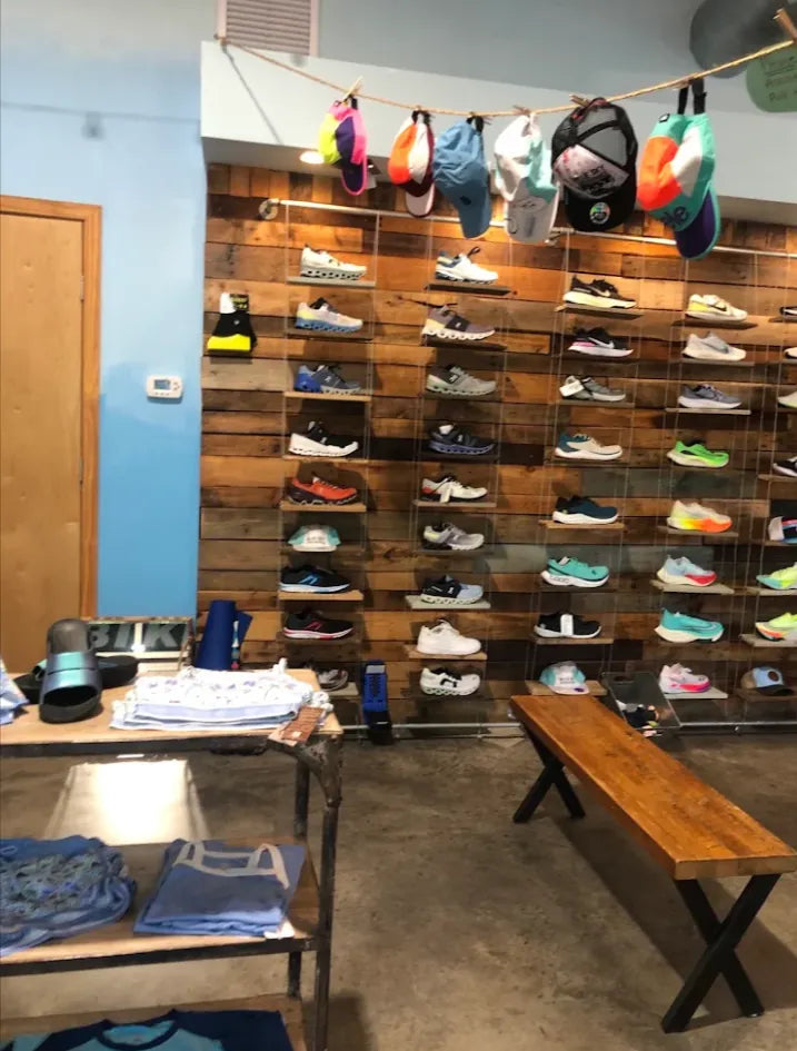 Shoe fitting bench in front of the running shoe wall at Blue Sky Endurance
