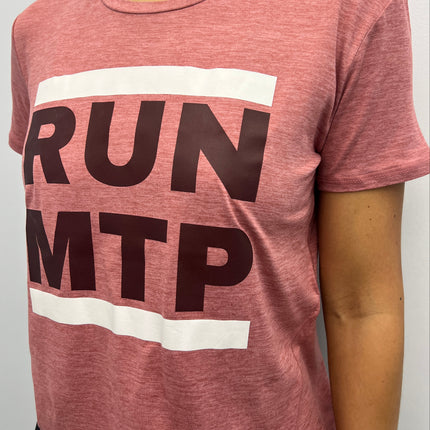 Person wearing a pink top with 'RUN MTP' text on a white background