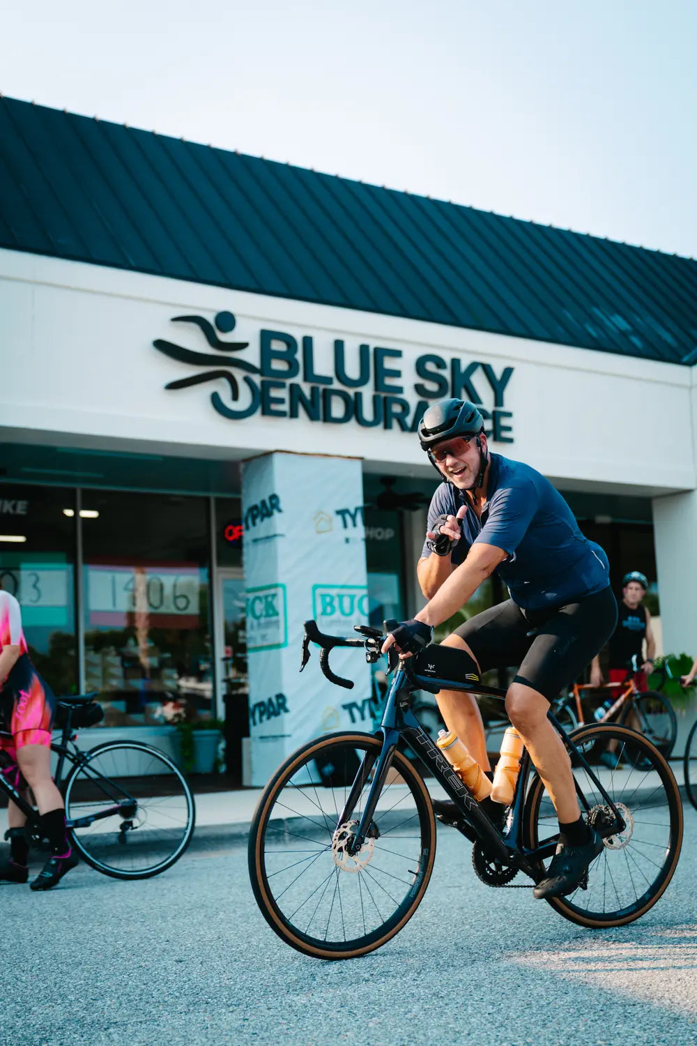 Cyclist riding out from the Blue Sky Endurance Coleman Blvd store at the start of a group ride