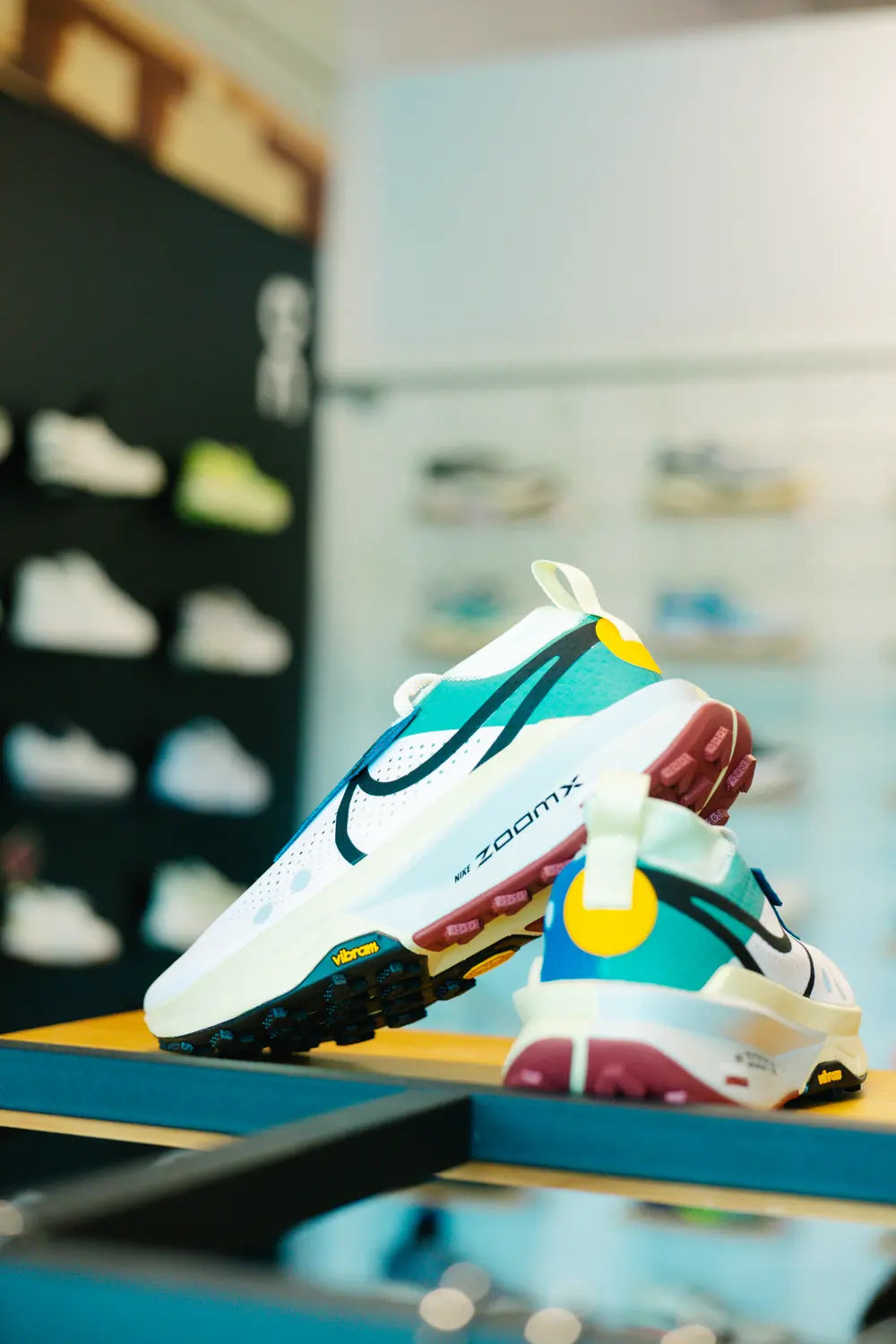 Running shoe on a display stand in front of the shoe wall