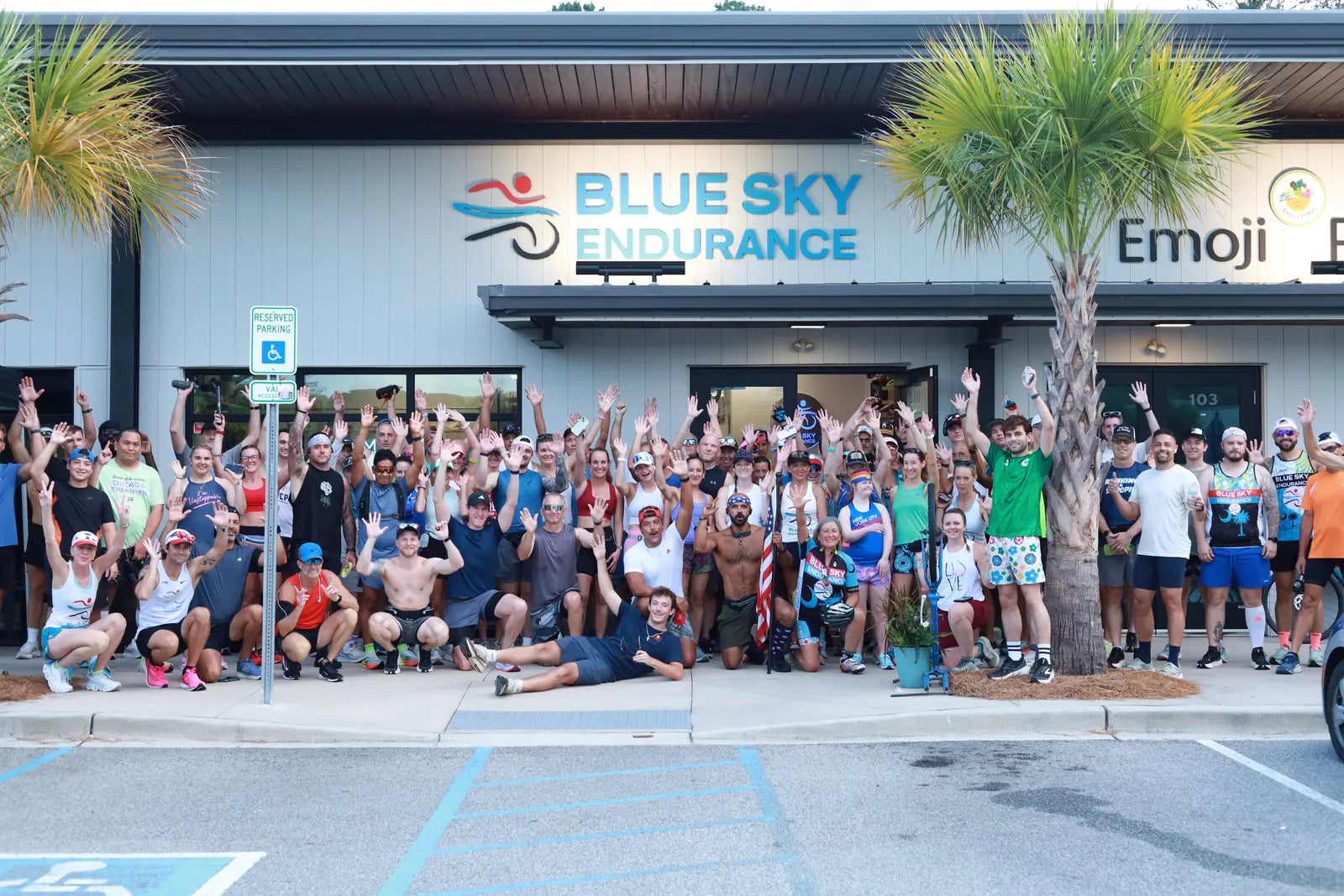 Crowd of runners and cyclists cheering in front of Blue Sky Endurance