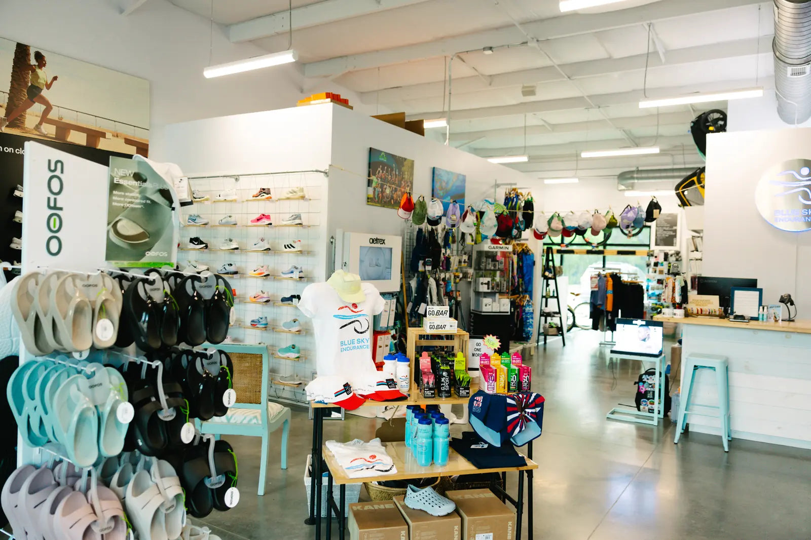 Wide view inside Blue Sky Endurance with OOFOS sandals, apparel and the shoe wall
