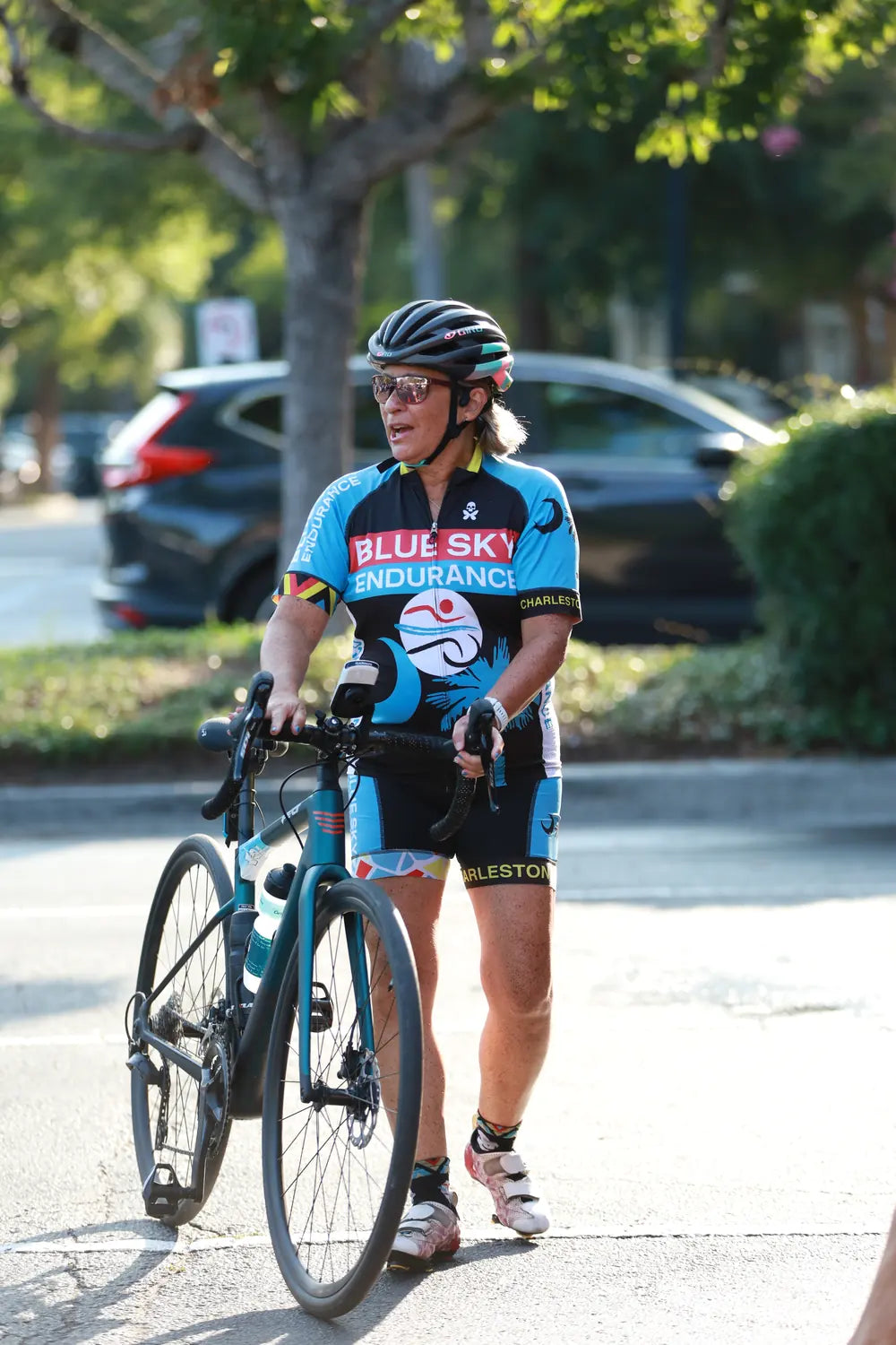 Cyclist in a Blue Sky Endurance kit standing with a road bike