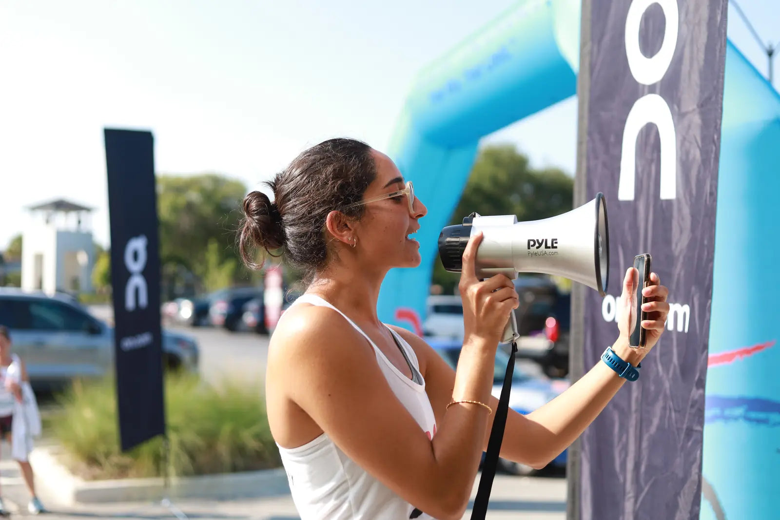 Race announcer with a megaphone at the start line of a Blue Sky Endurance race